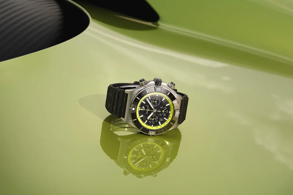 Breitling Super Chronomat B19 44 Perpetual Calendar Chronograph auf der limettengrünen Karosserie eines Aston Martin Valhalla