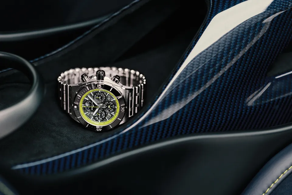 Breitling Super Chronomat on its Rouleaux bracelet in the carbon cockpit of an Aston Martin Valhalla