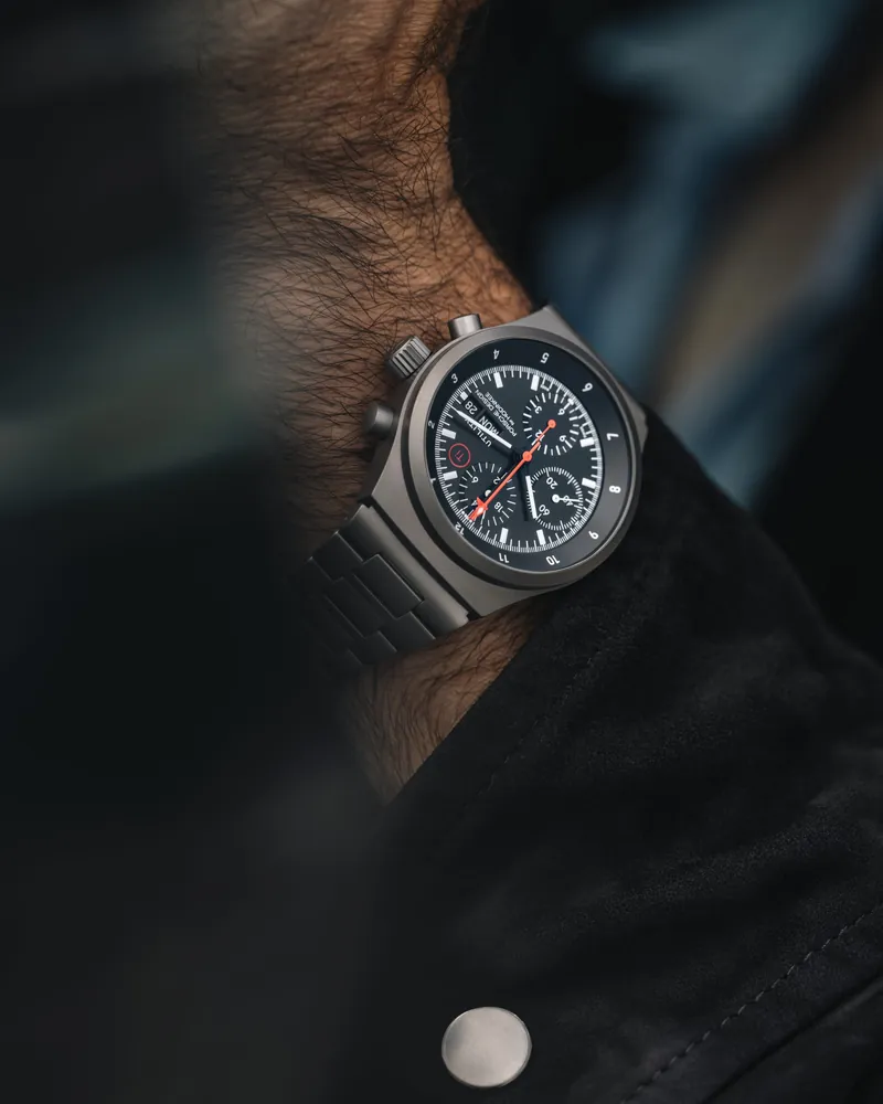 Porsche Design Chronograph 1 Utility am Handgelenk, schwarzes Zifferblatt und Titanarmband